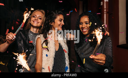 Trois femmes heureux de marcher et s'étreindre sur night street Banque D'Images