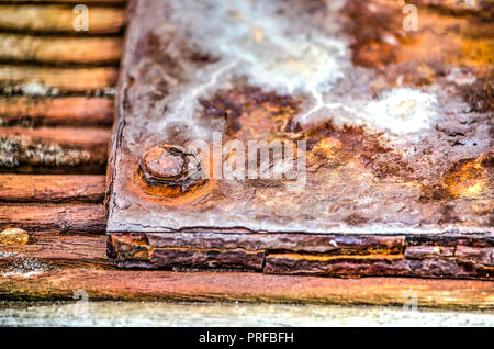 Close-up d'une très altérés et d'acier rouillé d'une borne d'amarrage sur une jetée en bois dans un port Banque D'Images