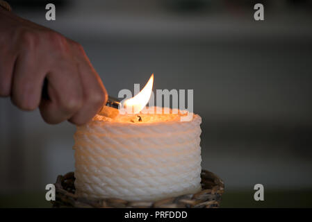 Bougie dans l'osier panier en bois debout sur la table à manger dans le restaurant ou sur le vert, lin naturel d'être allumé. Atmosphère romantique pour Banque D'Images