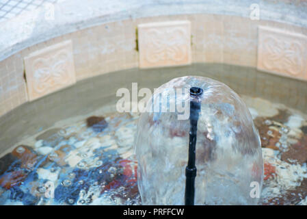 Petite fontaine intérieure dans une piscine avec pierres décoratives, galets et rochers. L'eau propre Banque D'Images