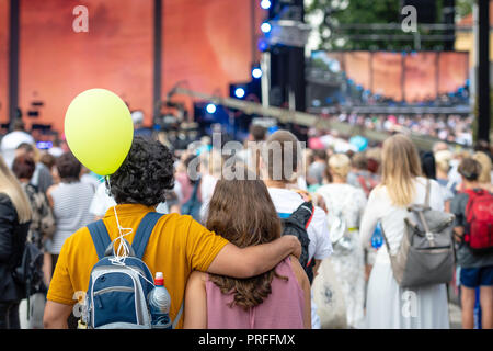 Embrassant les jeunes debout dans la foule et regarder un concert en plein air. Vue depuis l'arrière. Banque D'Images