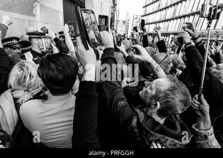 Les partisans de l'aile droite du film militant Tommy Robinson lui avec leurs téléphones portables laissant Court, London, UK Banque D'Images