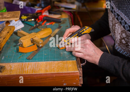 Professionnel hommes skinner, tanner travailler avec véritable cuir ceinture en atelier, studio. Et le travail du cuir fait main concept Banque D'Images