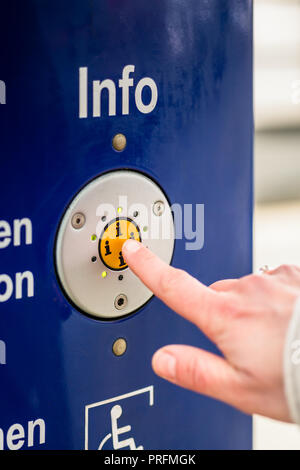 En appuyant sur le bouton info de la femme machine d'assistance en gare Banque D'Images