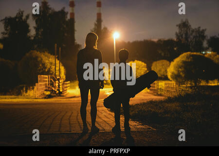 Femme avec son riding on longboard en parc de nuit Banque D'Images