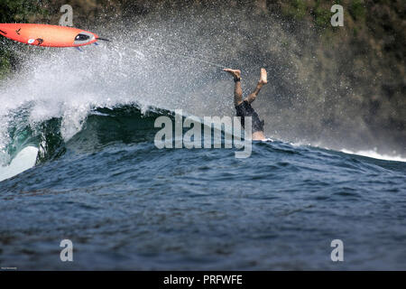 Surfer plongées sur fond de vague à Pangandaran, Java, Indonésie Banque D'Images