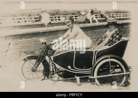 Deux dames posant pour la photo sur une moto et side-car de la SJA combinaison sur la plage au bord de la mer vers 1914/18 Banque D'Images