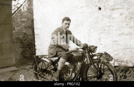 L'homme sur un Scout indien 1922 500cc Moto en face d'un mur de pierres peintes en blanc dans les années 1920 Banque D'Images