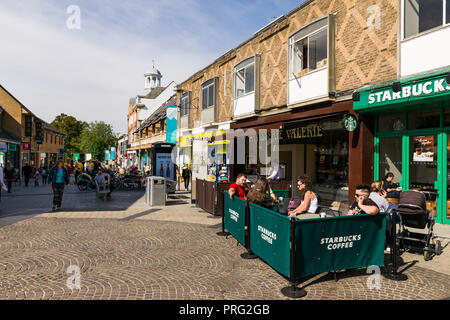 Vue sur la rue Fitzroy avec des magasins et des piétons sur une journée ensoleillée, les gens peuvent être vu assis à l'extérieur d'un café Starbucks, Cambridge, Royaume-Uni Banque D'Images