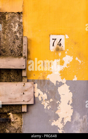 Yello en ruine et bleu mur avec un '74' Numéro de maison signe sur l'île de Procida, Naples, Italie Banque D'Images