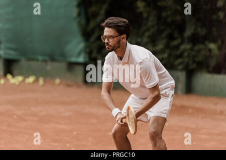 Concentré de style rétro tennis player pendant le jeu à court de tennis Banque D'Images