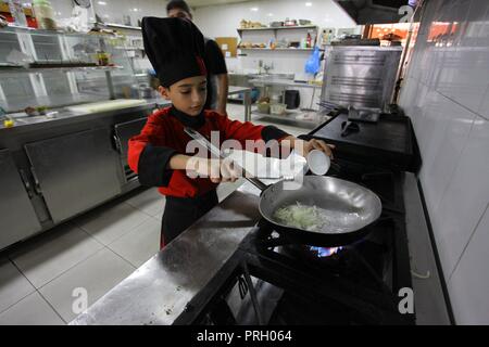 La ville de Gaza, bande de Gaza, territoire palestinien. 3e oct, 2018. Un garçon palestinien chef, Mohammed Abu Nada, 12 cuisiniers, le repas de l'ouest dans un restaurant dans la ville de Gaza le 3 octobre 2018 Crédit : Mahmoud Ajjour/APA/Images/fil ZUMA Alamy Live News Banque D'Images