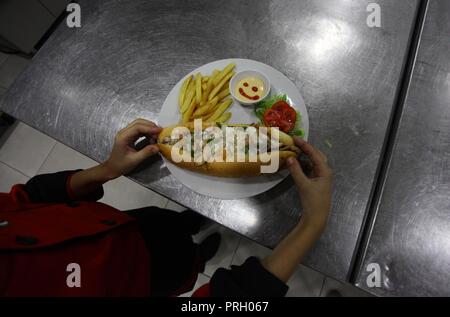 La ville de Gaza, bande de Gaza, territoire palestinien. 3e oct, 2018. Un garçon palestinien chef, Mohammed Abu Nada, 12, affiche sa cuisine dans un restaurant dans la ville de Gaza le 3 octobre 2018 Crédit : Mahmoud Ajjour/APA/Images/fil ZUMA Alamy Live News Banque D'Images