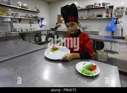 La ville de Gaza, bande de Gaza, territoire palestinien. 3e oct, 2018. Un garçon palestinien chef, Mohammed Abu Nada, 12 cuisiniers, le repas de l'ouest dans un restaurant dans la ville de Gaza le 3 octobre 2018 Crédit : Mahmoud Ajjour/APA/Images/fil ZUMA Alamy Live News Banque D'Images