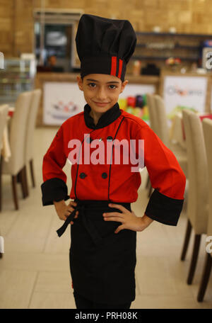 La ville de Gaza, bande de Gaza, territoire palestinien. 3e oct, 2018. Un garçon palestinien chef, Mohammed Abu Nada, 12 ans, pose pour une photo dans un restaurant dans la ville de Gaza le 3 octobre 2018 Crédit : Mahmoud Ajjour/APA/Images/fil ZUMA Alamy Live News Banque D'Images