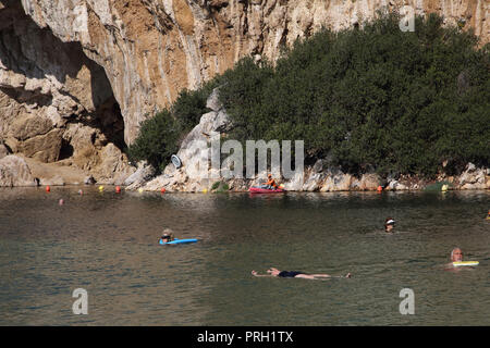 Vouliagmeni Athènes Grèce touristes nager dans le lac Vouliagmeni un Spa naturel - était une fois une caverne, mais le toit de la grotte est tombé en raison de l'érosion de la Banque D'Images