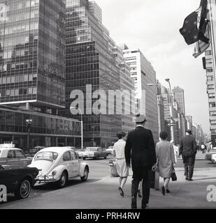 Années 1960, scène de rue, les New-Yorkais sur leur de travailler dans une rue avec verre moderne, dominé de tours à Manhattan, New York, USA. Banque D'Images