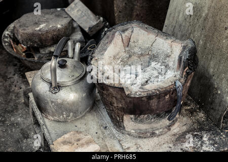 Old grunge cuisinière asiatique avec brûler du charbon de bois et électrique pot cuisine rurales pauvres. Banque D'Images