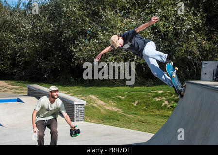 Une planche d'être filmé effectuant un tour sur une rampe à vagues de béton à Newquay en Cornouailles. Banque D'Images