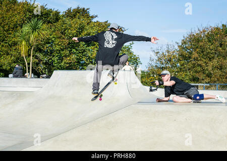 Une planche d'être filmé l'exécution d'une tour d'antenne à des vagues de béton parc de planche à roulettes à Newquay en Cornouailles. Banque D'Images