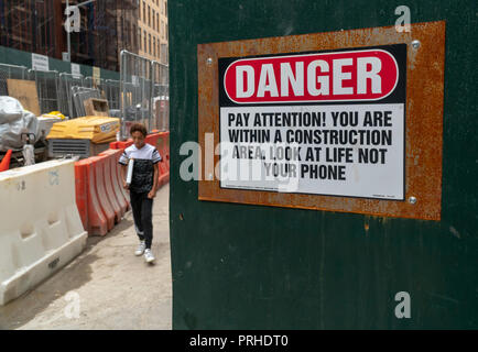 Un panneau d'avertissement sur un site de construction à New York rappelle à smartphone utilise pour regarder où ils vont, vu le Lundi, Octobre 1, 2018. (Â© Richard B. Levine) Banque D'Images