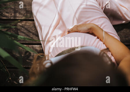High angle view of pregnant woman holding her belly Banque D'Images
