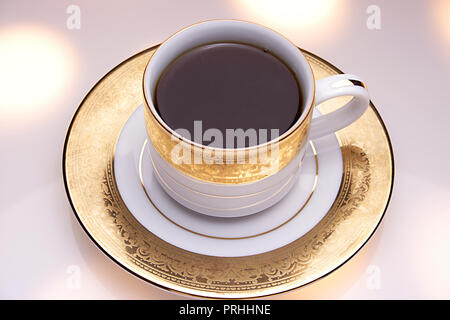 Café régulier dans une tasse sur un fond blanc. Banque D'Images