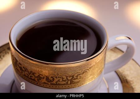 Café régulier dans une tasse sur un fond blanc. Banque D'Images