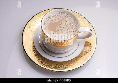 Café régulier dans une tasse sur un fond blanc. Banque D'Images