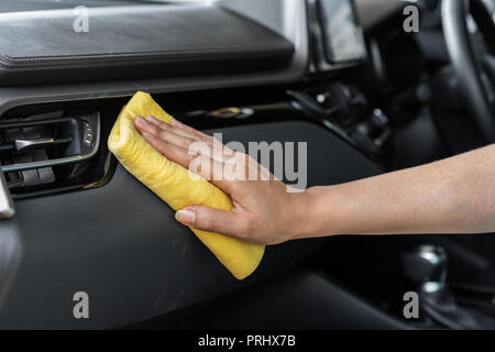 La main avec chiffon microfibre nettoyage d'une console de voiture Banque D'Images