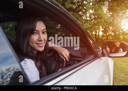 Happy young woman in a car Banque D'Images