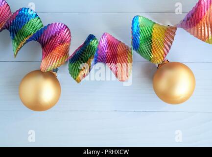 Concept de vacances festives avec ruban brillant et coloré, or boules de noël, bleu fond de bois et copy space Banque D'Images