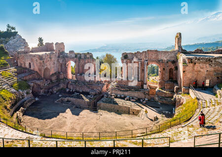 Taormina / ITALIE - 29 décembre 2015 : Vue de la Teatro Greco (Théâtre Grec Antique) avec la mer Ionienne et l'etna enneigé de fumer. Banque D'Images