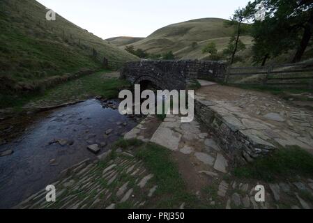 Pont pied en pierre au bas de l'échelle de Jacob célèbre sentier dans le Peak District, Derbyshire Banque D'Images
