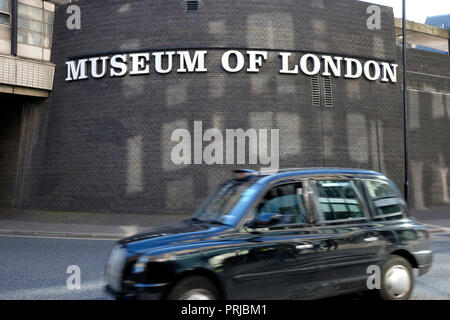 Un taxi noir passé lecteurs le Museum of London Banque D'Images