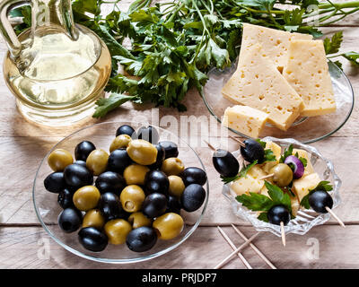 Canape d'olives et des olives avec du fromage et des verts, olives et fromage dans une assiette, parsley on a wooden background Banque D'Images