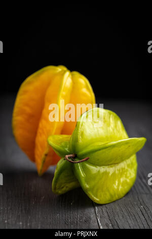 Venu de jaune et de vert carambole carambole ou étoile ( apple ) caramboles sur fond sombre Banque D'Images