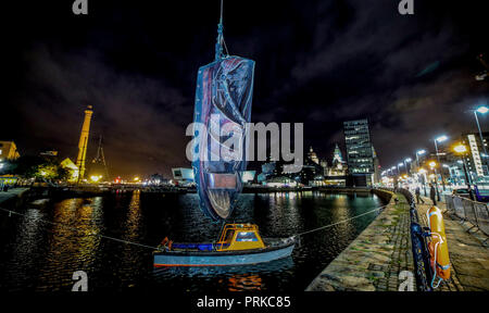 Un géant sandale est suspendu au-dessus d'un petit bateau dans le cadre de la Royal de Luxe spectaculaire géants, Liverpool's Dream, qui commence le vendredi à Liverpool et le Wirral. Banque D'Images