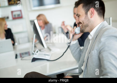 Businessman dans le bureau parler au téléphone Banque D'Images