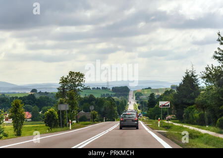 Route avec un flux de voitures sur la ville de Rzeszow en Pologne, en passant par les Carpates le long du village. Banque D'Images