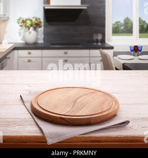 Vide table en bois avec planche à pizza et cirée près de la fenêtre de cuisine. Serviette blanche close up Vue de dessus la maquette pour la conception. Rustique cuisine arrière-plan. Banque D'Images