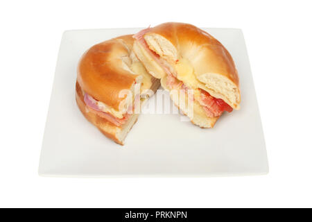 Croque-fromage, jambon, l'oignon et la tomate bagel coupé en deux sur une plaque isolés contre white Banque D'Images