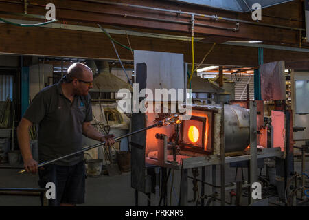 Souffleur de verre d'une traite chauffées dans un four. Banque D'Images