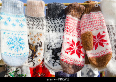 Mitaines d'hiver au Marché de Noël. Une variété de tricots colorés mitaines de laine accroché à une corde. Cadeau de Noël ou un souvenir. Banque D'Images