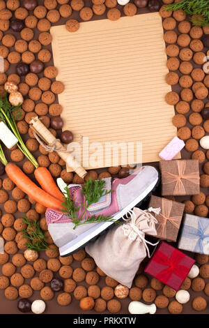 Vacances hollandaises Sinterklaas fond avec des chaussures pour enfants avec des carottes pour le Père Noël, le cheval, le pepernoten et les bonbons. Lettre traditionnelle avec cadeaux de vacances. Copier l'espace. Vue de dessus Banque D'Images