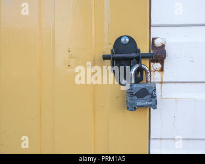 Cadenassé porte d'une cabane de plage à Newquay, Cornwall. Bien en place, fixez-le en métaphore. Banque D'Images