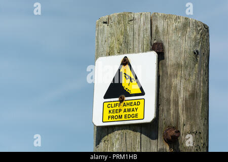 Un triangle jaune d'avertissement mettant en évidence le bord d'une falaise dangereuse à proximité. Tenir éloigné du concept de bord, tomber, tomber le pictogramme de l'homme en chute libre. Banque D'Images