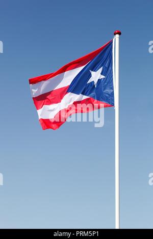 Brandissant le drapeau de Porto Rico dans le ciel Banque D'Images