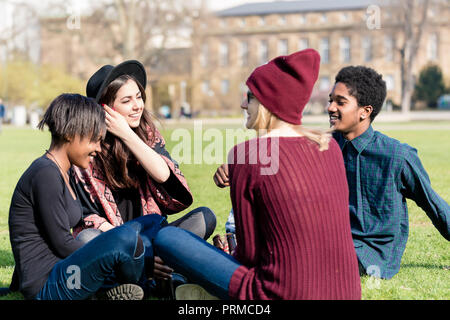 Groupe de professionnels multi ethnic amis assis ensemble dans le parc Banque D'Images