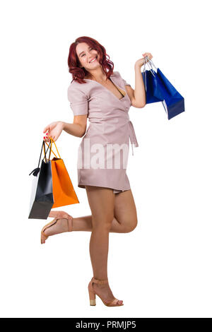 Belle jeune femme heureuse avec jambe pliée après shopping vente isolated over white background. Banque D'Images